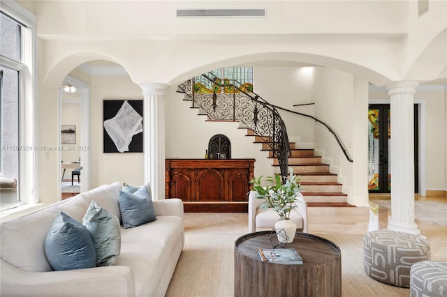 living room featuring ornamental molding, light colored carpet, and ornate columns