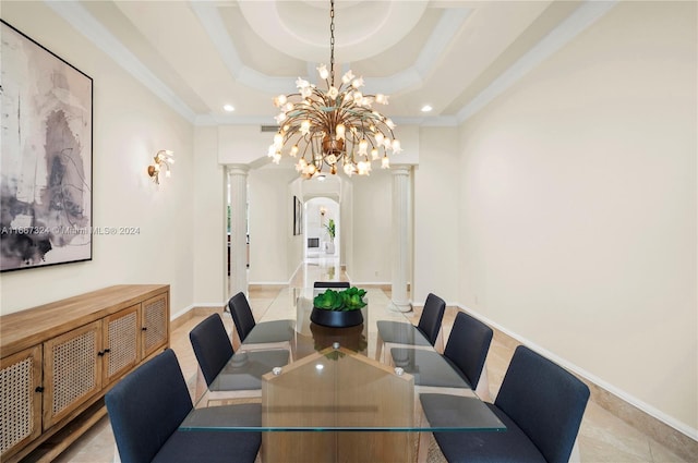 dining space featuring ornamental molding, decorative columns, a tray ceiling, and a notable chandelier