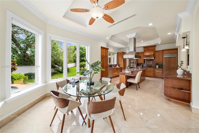 dining room with crown molding, a tray ceiling, and ceiling fan