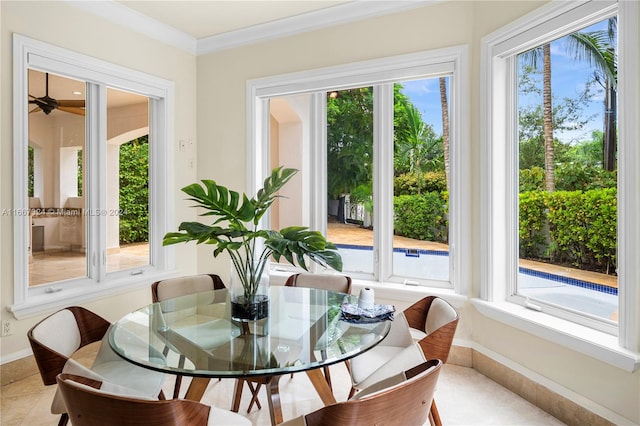 tiled dining area with ornamental molding and a wealth of natural light