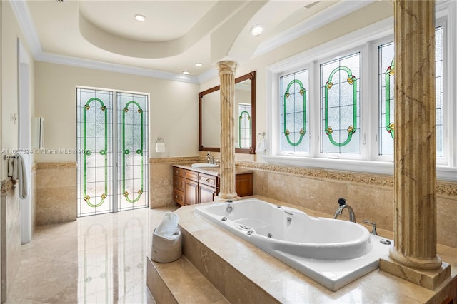 bathroom featuring a relaxing tiled tub, vanity, plenty of natural light, and ornate columns