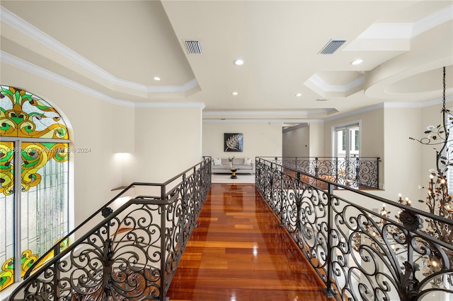 hallway featuring dark hardwood / wood-style flooring, a raised ceiling, and crown molding