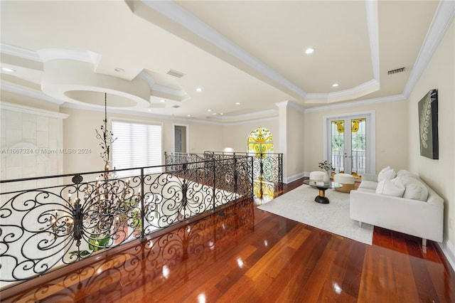 hallway featuring wood-type flooring, a raised ceiling, french doors, and crown molding