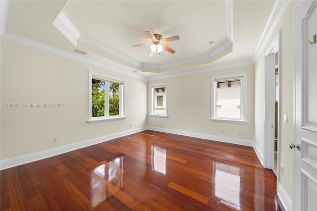 spare room featuring ornamental molding, ceiling fan, a raised ceiling, and dark wood-type flooring