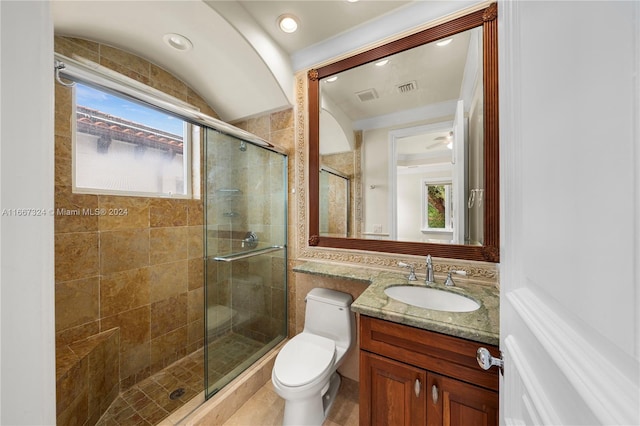 bathroom with vanity, plenty of natural light, toilet, and a shower with door