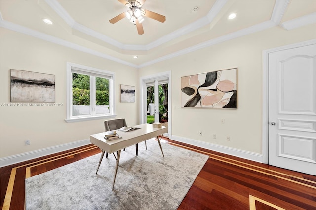 home office with a tray ceiling, ceiling fan, dark wood-type flooring, and crown molding