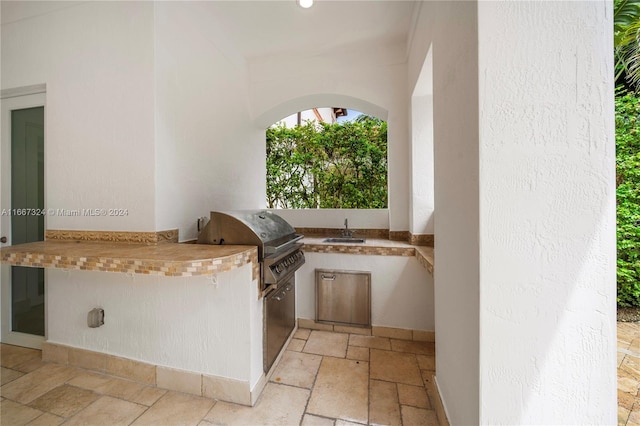 view of patio / terrace with a grill, sink, and exterior kitchen