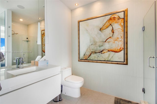 bathroom featuring vanity, a shower with shower door, toilet, and tile patterned floors