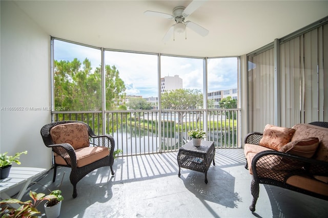 sunroom featuring a water view and ceiling fan