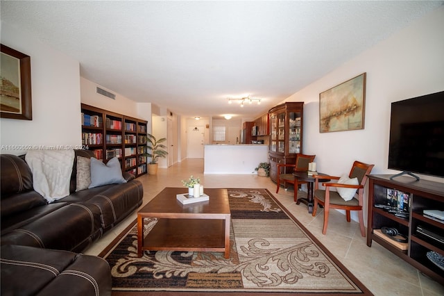 living room featuring light tile patterned flooring and a textured ceiling