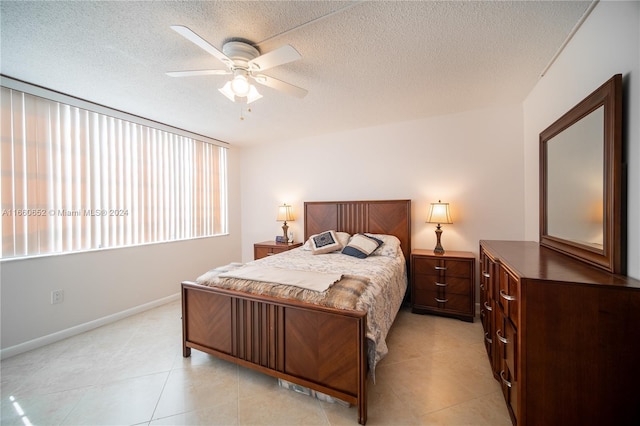 tiled bedroom featuring ceiling fan and a textured ceiling