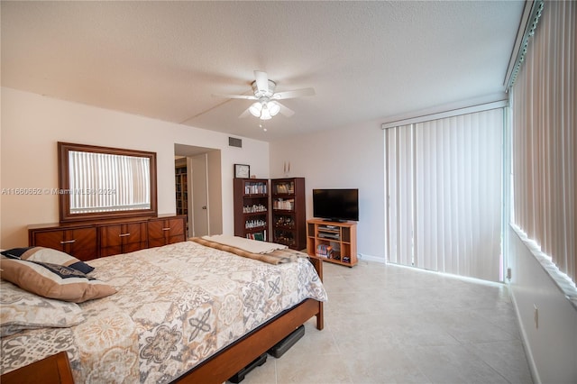 bedroom with ceiling fan and a textured ceiling