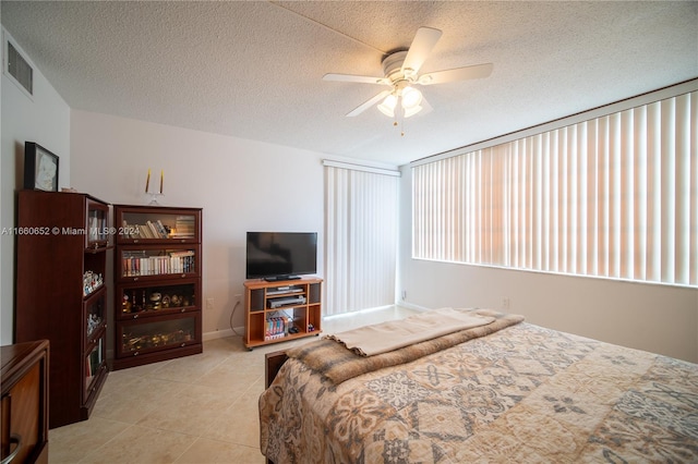 tiled bedroom featuring a textured ceiling and ceiling fan