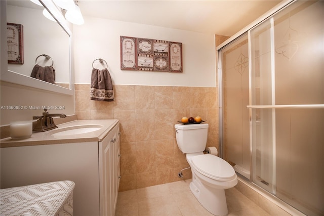 bathroom featuring tile walls, an enclosed shower, vanity, and toilet