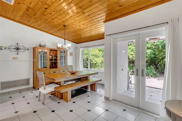 dining space featuring french doors, wooden ceiling, a notable chandelier, crown molding, and vaulted ceiling