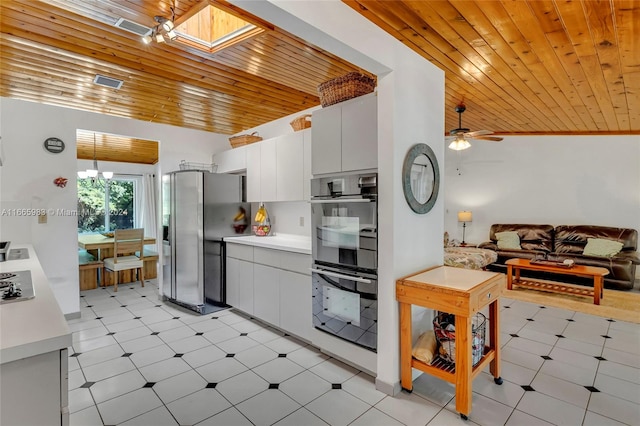 kitchen featuring wood ceiling, white cabinets, lofted ceiling with skylight, ceiling fan, and stainless steel fridge with ice dispenser