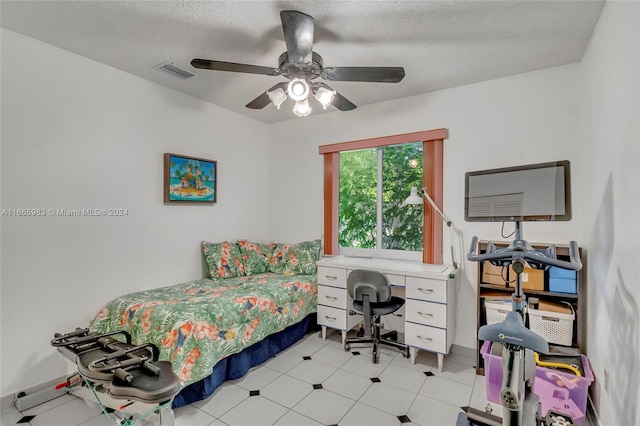 bedroom with ceiling fan and a textured ceiling