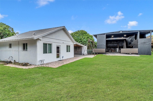 rear view of house with a lawn and a patio