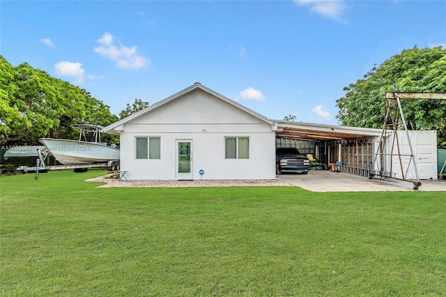 rear view of property with a carport and a yard