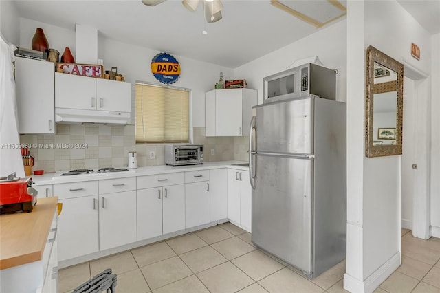 kitchen featuring ceiling fan, white cabinets, light tile patterned floors, backsplash, and stainless steel appliances