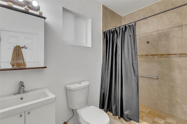 bathroom with walk in shower, vanity, and toilet