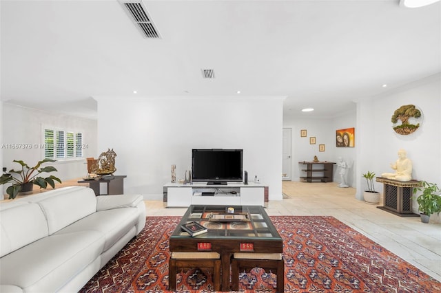 living room with crown molding and light tile patterned floors