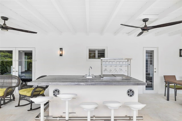 kitchen with beamed ceiling, french doors, and sink