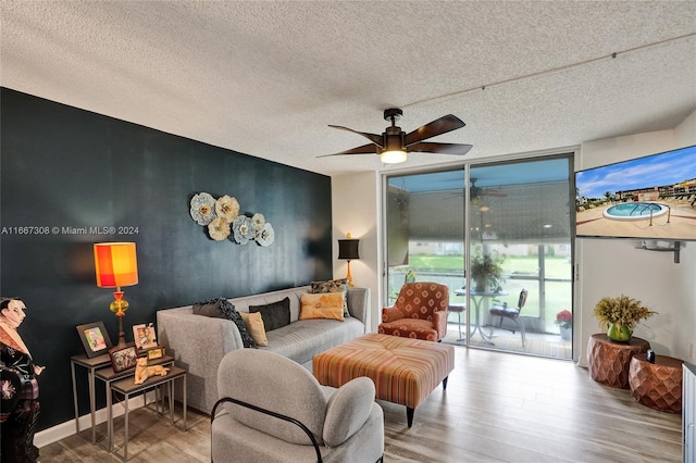 living room featuring a textured ceiling, floor to ceiling windows, ceiling fan, and hardwood / wood-style flooring