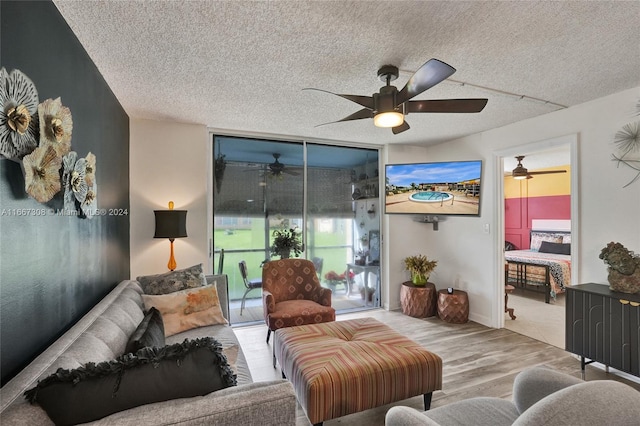 living room featuring ceiling fan, a textured ceiling, and light hardwood / wood-style flooring