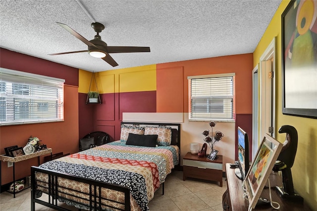 tiled bedroom featuring ceiling fan, a textured ceiling, and multiple windows