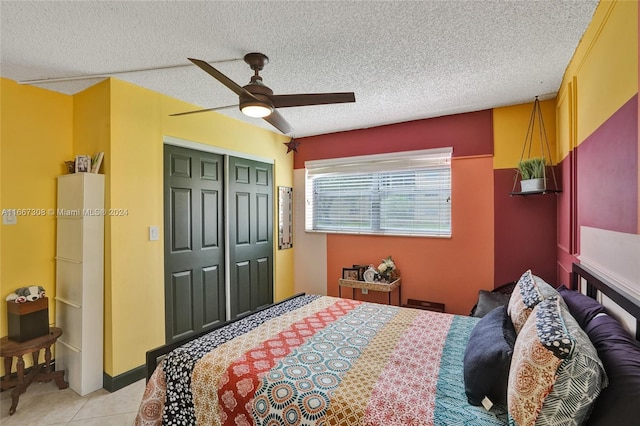 tiled bedroom featuring ceiling fan, a textured ceiling, and a closet