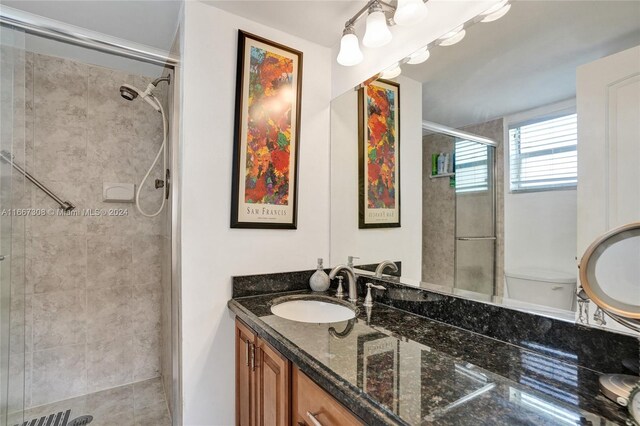 bathroom featuring walk in shower, vanity, and toilet