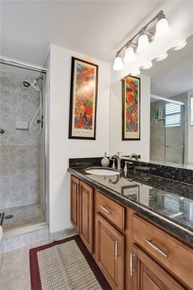 bathroom with vanity, a shower with shower door, and tile patterned floors