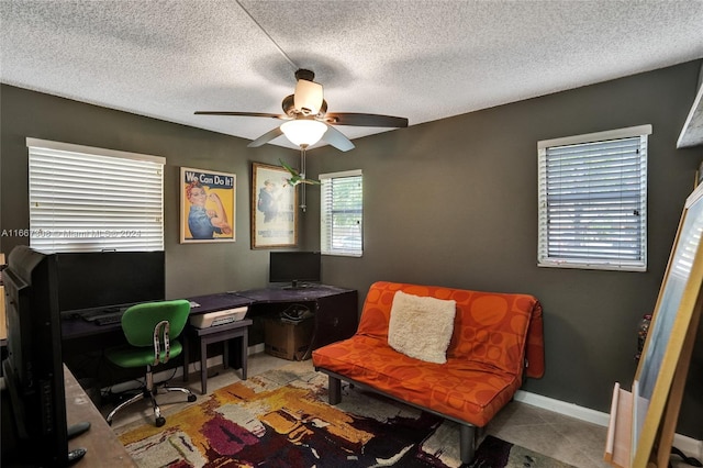 home office with a textured ceiling, light tile patterned floors, and ceiling fan