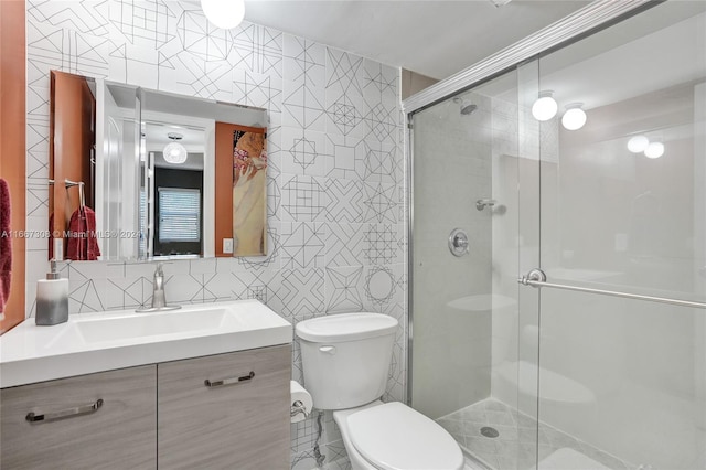 bathroom featuring tile walls, vanity, toilet, and a shower with door