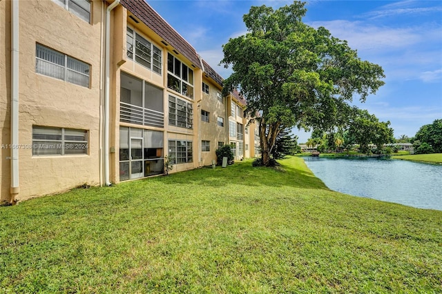 view of community featuring a lawn and a water view