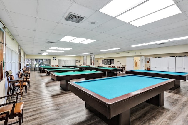 recreation room with pool table, a drop ceiling, and hardwood / wood-style flooring