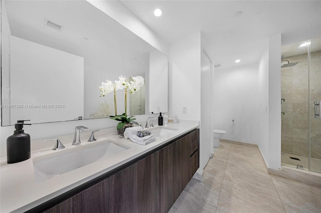 bathroom featuring tile patterned flooring, walk in shower, vanity, and toilet