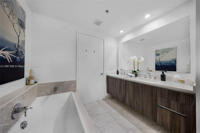 bathroom featuring vanity, tile patterned floors, and a washtub