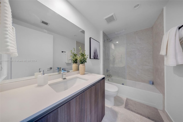 full bathroom featuring tiled shower / bath, vanity, toilet, and tile patterned floors