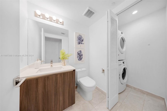 bathroom with tile patterned floors, stacked washer / drying machine, vanity, and toilet