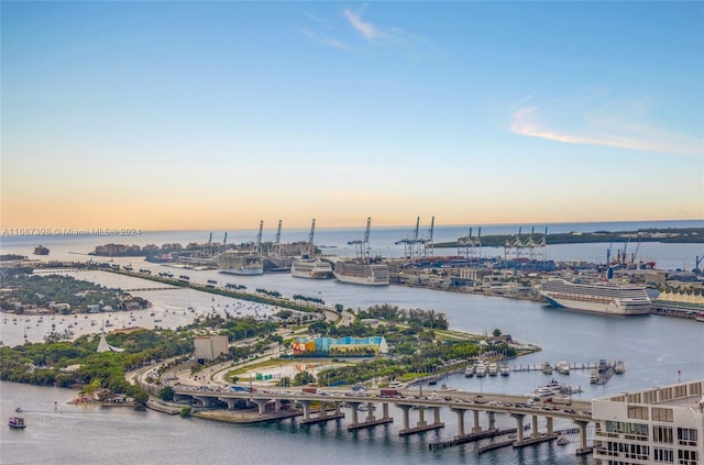 aerial view at dusk featuring a water view