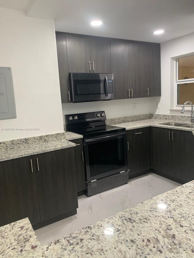 kitchen with light stone counters, electric panel, sink, dark brown cabinetry, and black range with electric cooktop