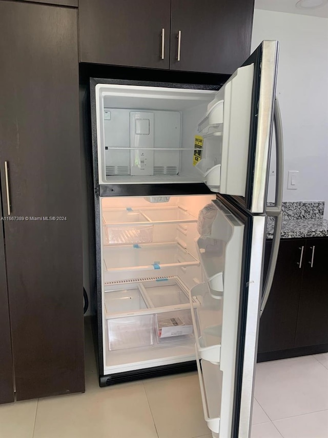 details with light tile patterned floors and stainless steel refrigerator