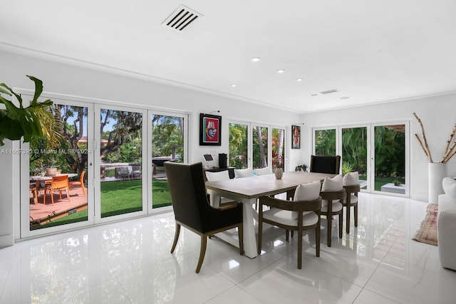 dining space featuring ornamental molding and light tile patterned flooring