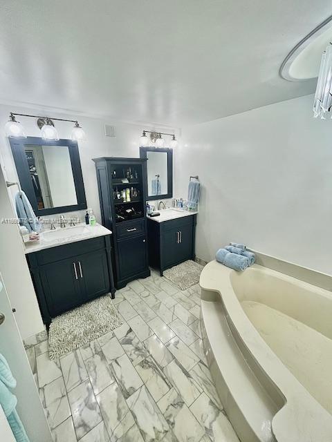 bathroom with a tub and vanity