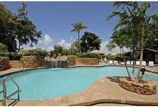 view of swimming pool with pool water feature