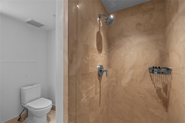 bathroom featuring a tile shower and toilet