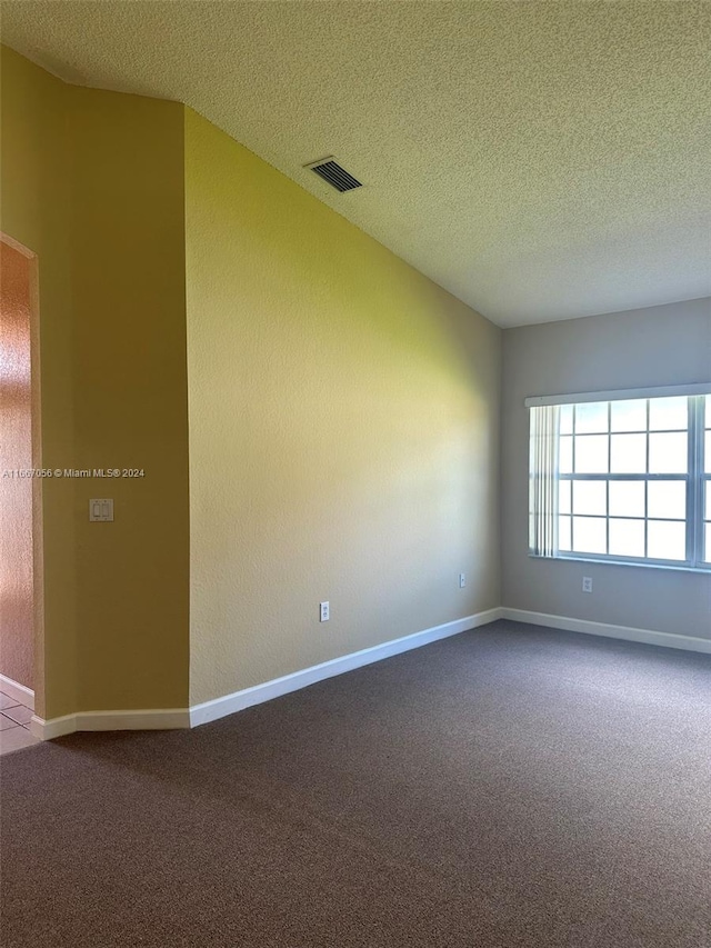 carpeted empty room featuring a textured ceiling