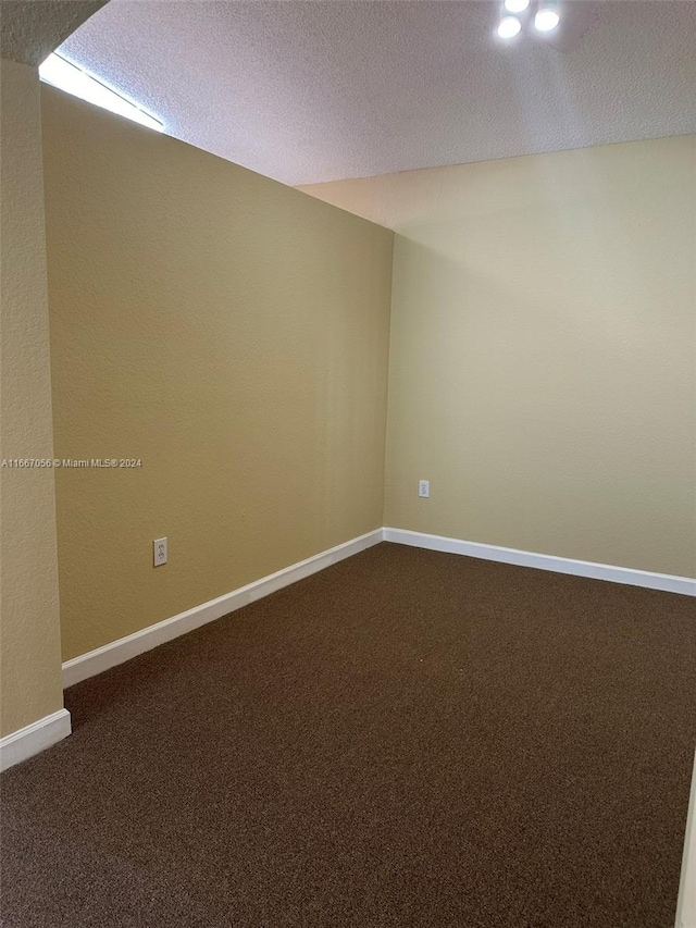 carpeted empty room with a textured ceiling